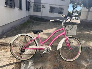 Bicicleta rosa estilo cruiser con cesta