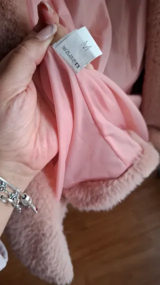 Abrigo rosa ,de pelo, con capucha,tiene forro.