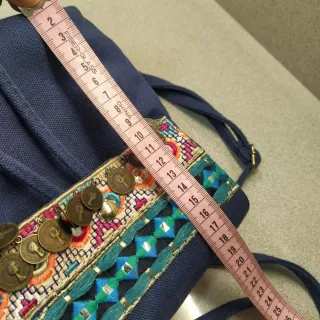Mochila azul con bordado y monedas
