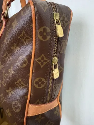 Bolso de lujo tipo maletin con monograma clásico.