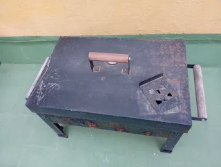 Barbacoa metálica negra con asa de madera