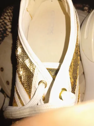 Zapatillas doradas y blancas