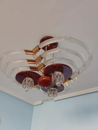 Lámpara de salón dorada y transparente.