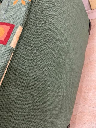 Sofá de tela verde con funda marrón