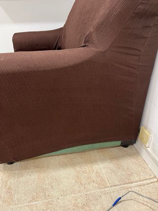 Sofá de tela verde con funda marrón