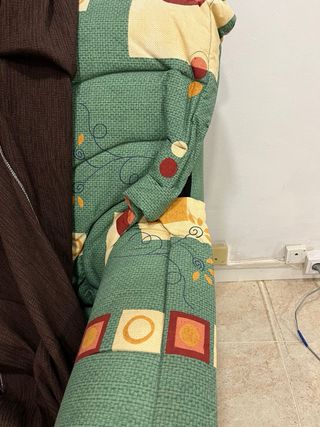 Sofá de tela verde con funda marrón