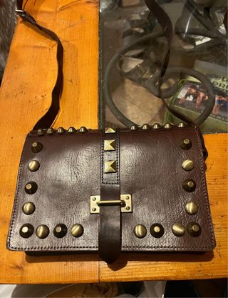 Bolso de cuero marrón con tachuelas
