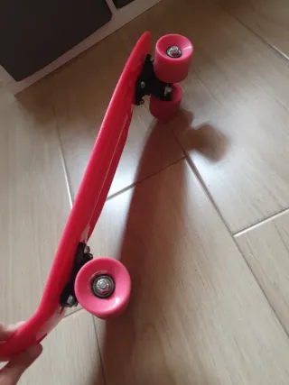 Monopatín rosa con diseño de escamas