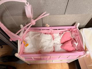 Cuna de muñecas rosa con móvil musical