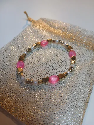 Pulseras doradas y rosas con corazones