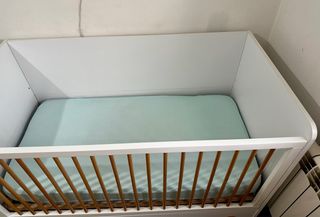 Cuna blanca con barrotes de madera