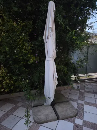 Ombrellone beige con base in pietra