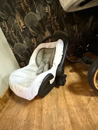 Carrito de bebé blanco con detalles negros dorados