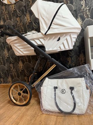 Carrito de bebé blanco con detalles negros dorados