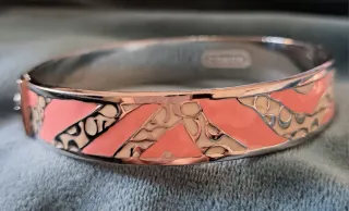 Pulsera Coach dorada y rosa, o plateado y rosa.