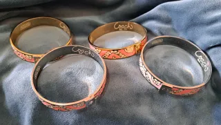 Pulsera Coach dorada y rosa, o plateado y rosa.