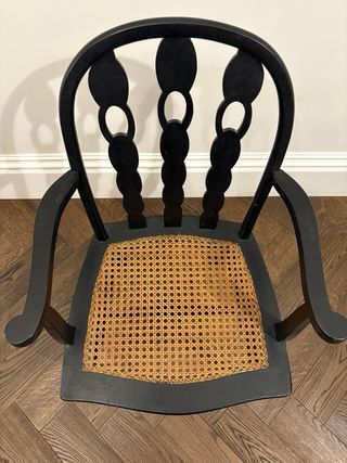 Silla de madera negra con asiento de ratán