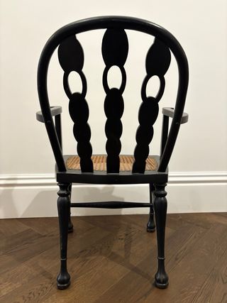 Silla de madera negra con asiento de ratán