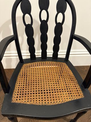 Silla de madera negra con asiento de ratán