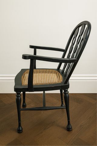 Silla de madera negra con asiento de ratán