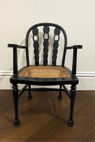 Silla de madera negra con asiento de ratán
