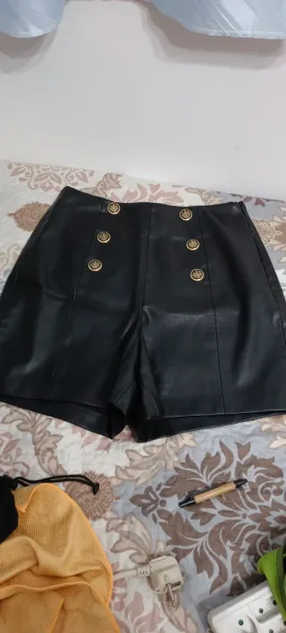 Shorts de cuero negro con botones dorados