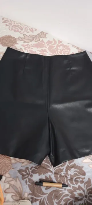 Shorts de cuero negro con botones dorados