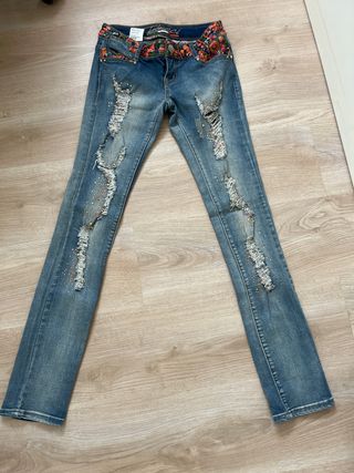 Pantalón vaquero desgarrado con bordado y rotos.