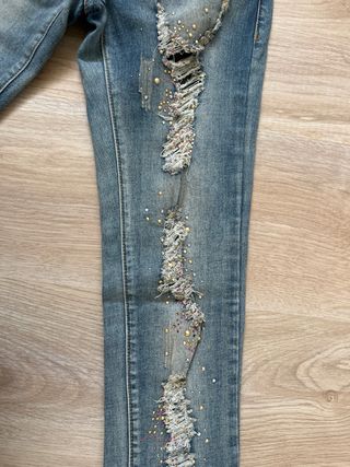 Pantalón vaquero desgarrado con bordado y rotos.