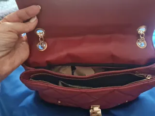 Bolso rojo con tachuelas doradas.