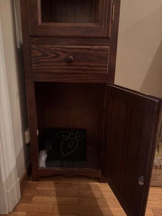 Mueble de madera con vitrina y cajón.
