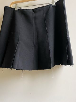 Falda mini negra, tablas en abertura fluida