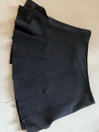 Falda mini negra, tablas en abertura fluida