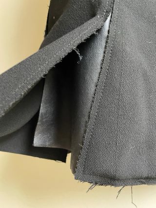 Falda mini negra, tablas en abertura fluida