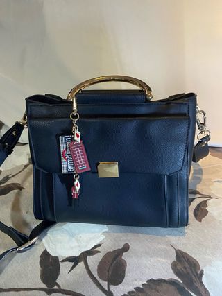 Bolso negro con asa dorada y llavero