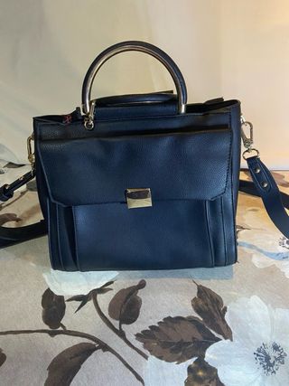 Bolso negro con asa dorada y llavero