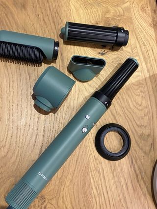 secador tipo Dyson con accesorio y neceser