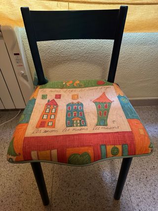 Silla de madera azul con cojín estampado