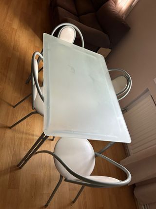 Mesa de cristal y sillas metálicas