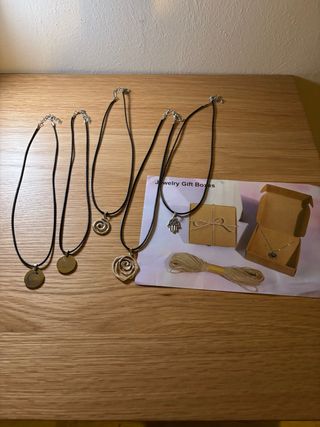 5 collane con ciondoli e scatole nuove.