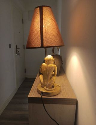 Lámpara mono dorado sentado