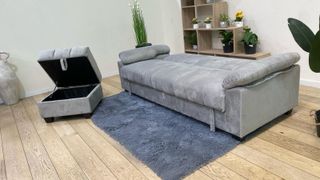 Sofá cama gris con cojín de oferta