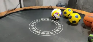 Cama elástica naranja con red de seguridad