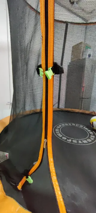 Cama elástica naranja con red de seguridad