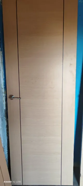 Puerta de madera clara con manilla