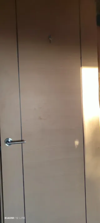 Puerta de madera clara con manilla