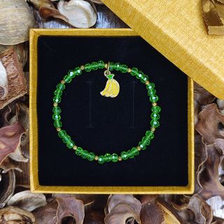 Pulsera cristal verde con charm plátanos dorados