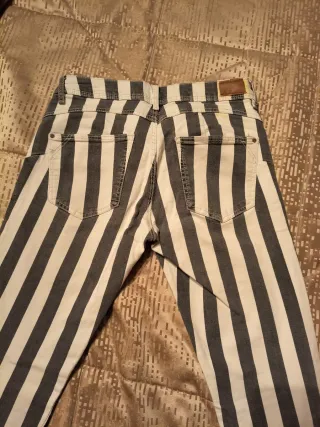 Pantalón pitillo rayas gris y blanco.