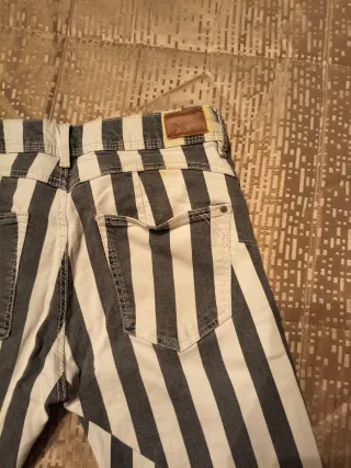 Pantalón pitillo rayas gris y blanco.