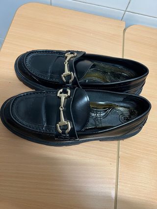 Mocasines negros con hebilla dorada